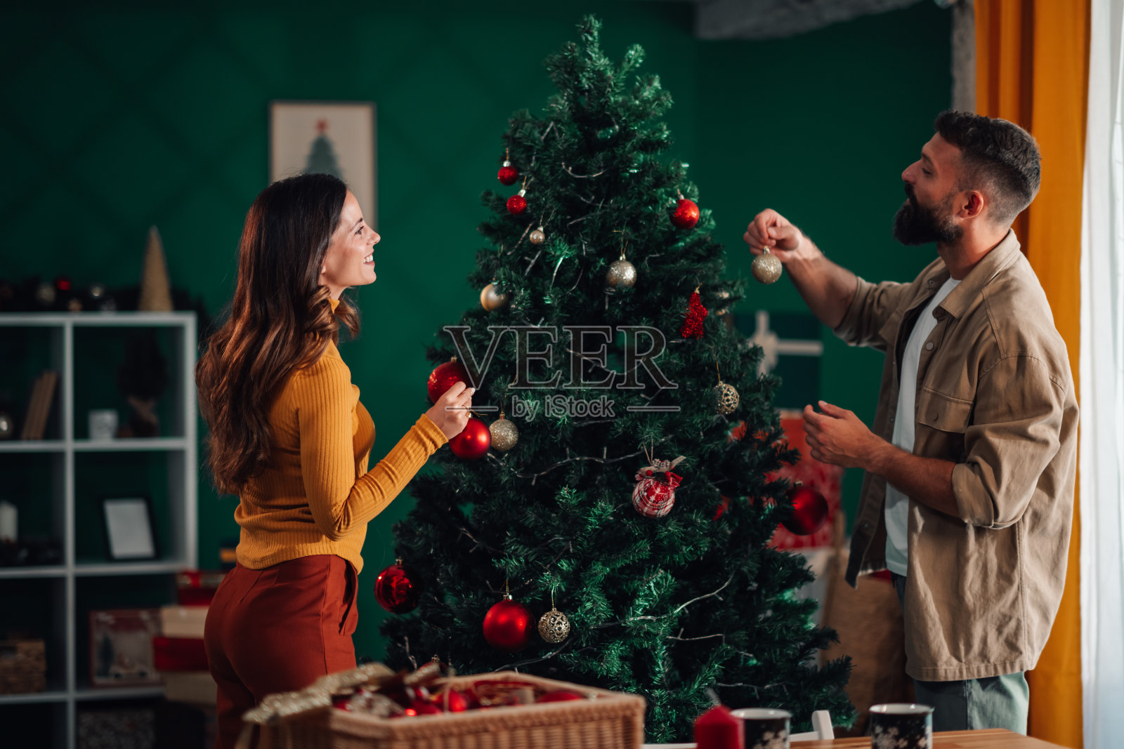年轻情侣在家装饰圣诞树照片摄影图片