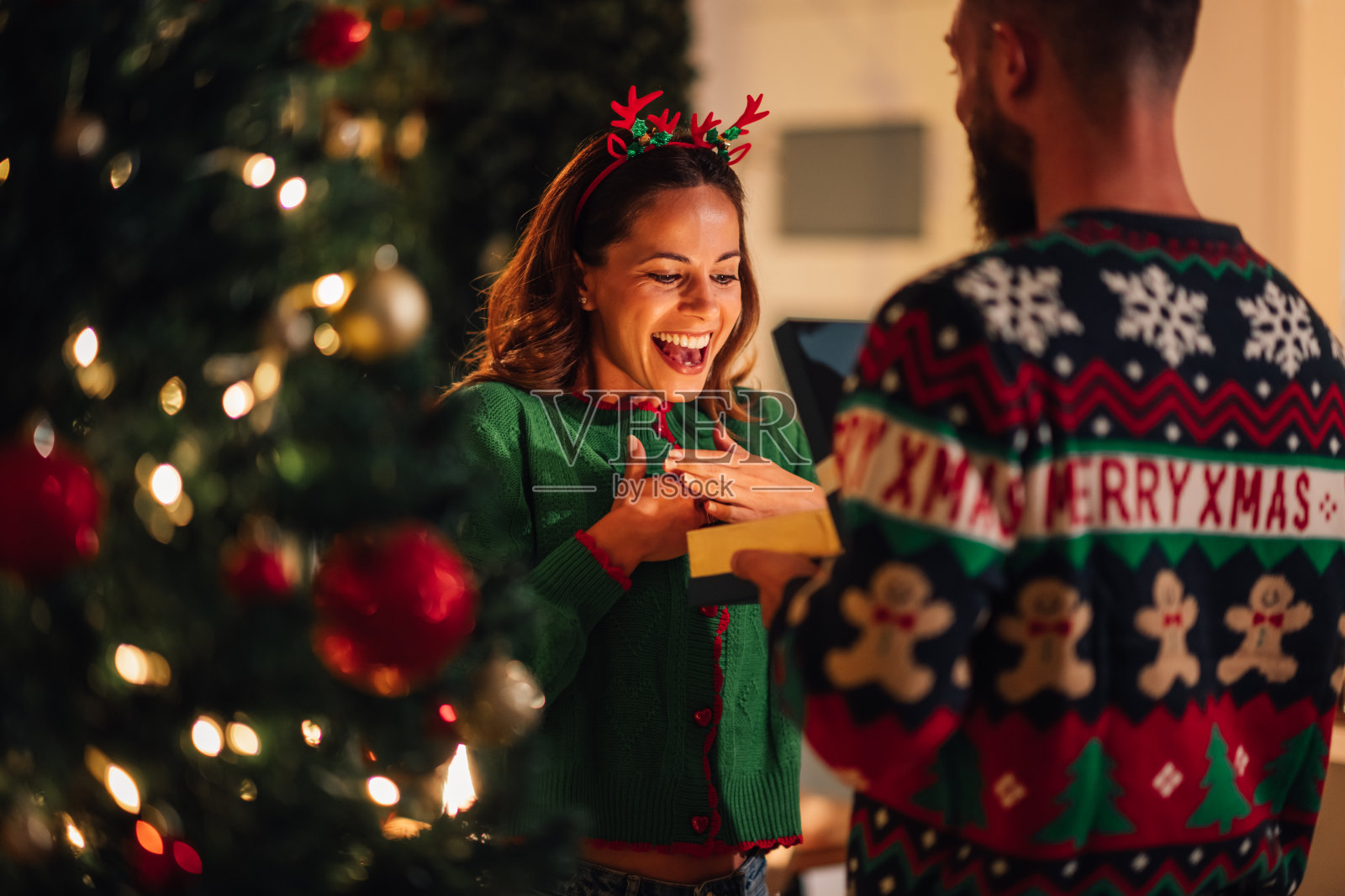 惊讶的女人收到丈夫的圣诞礼物照片摄影图片