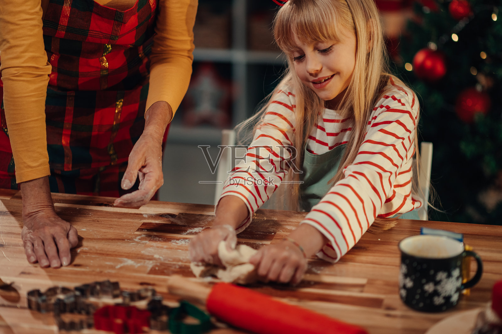 女孩和祖母一起揉面团，准备圣诞饼干。照片摄影图片