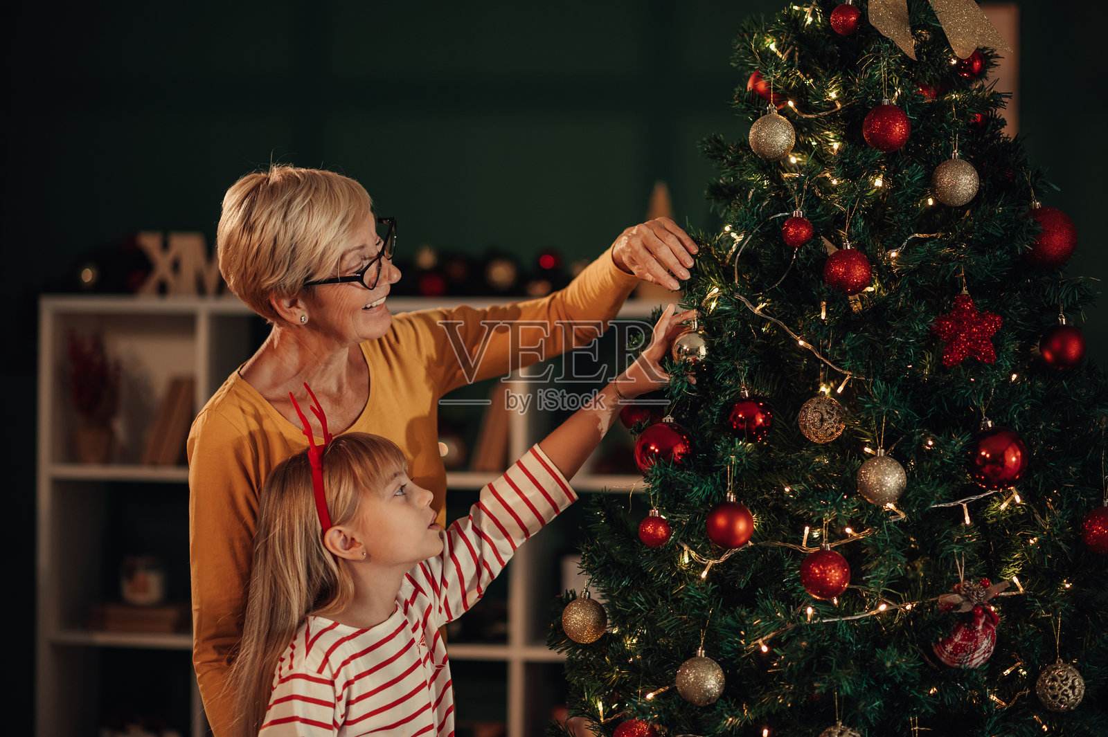祖母和孙女在家一起装饰圣诞树照片摄影图片