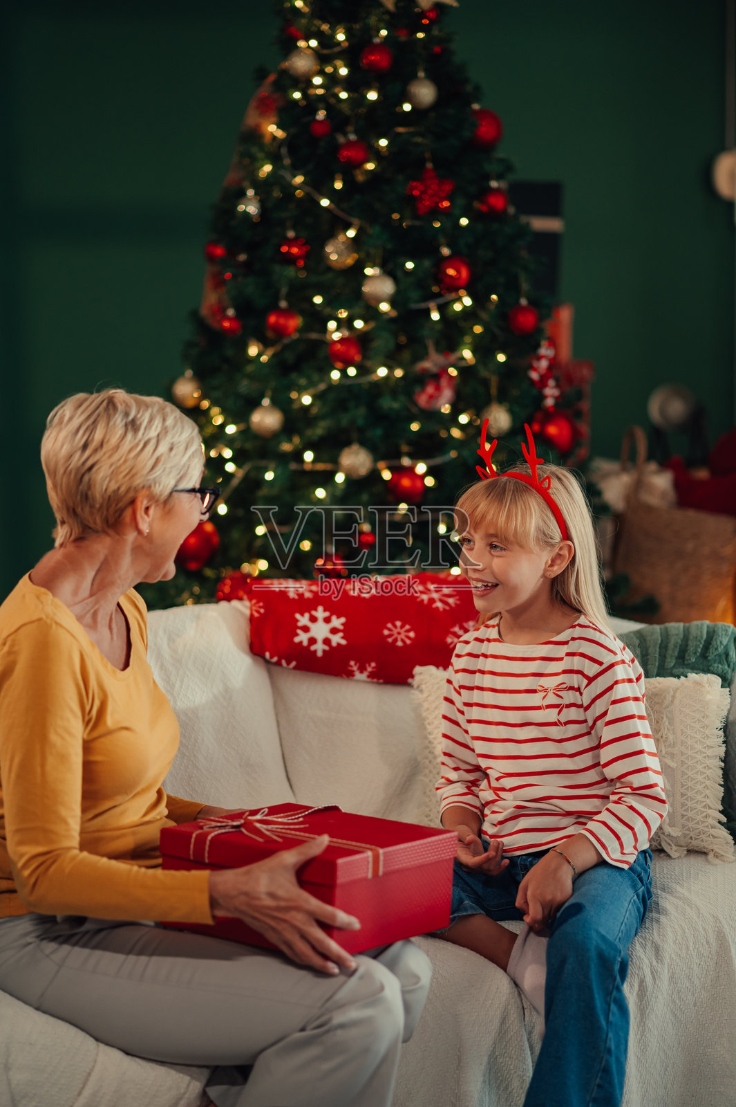 祖母在家中给孙女送圣诞礼物照片摄影图片