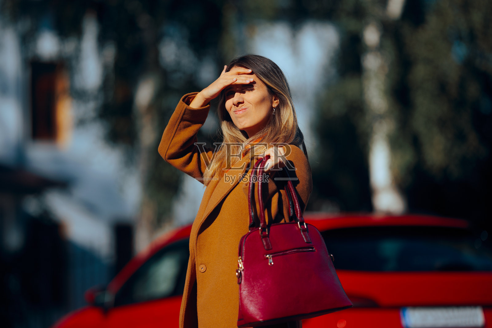女人在阳光下感到不适，努力想要看清楚。照片摄影图片