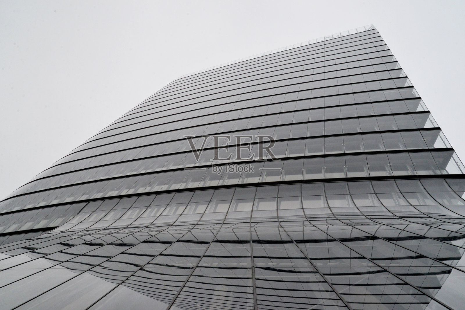 现代玻璃摩天大楼，曲线设计，阴天照片摄影图片