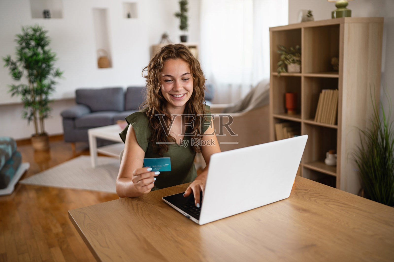 年轻女性在家中使用笔记本电脑和信用卡进行在线购物照片摄影图片