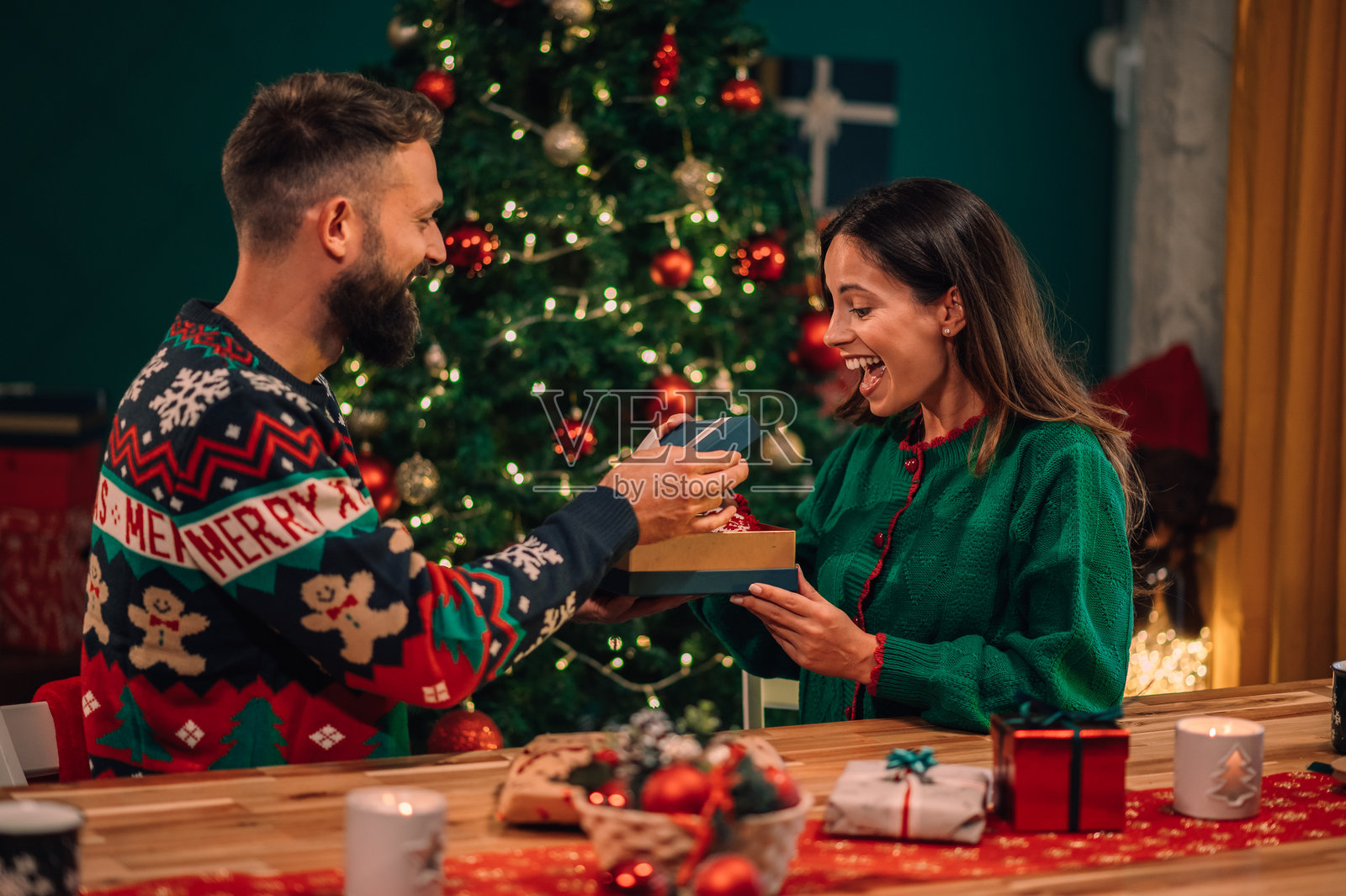 快乐的情侣在家中互赠圣诞礼物照片摄影图片