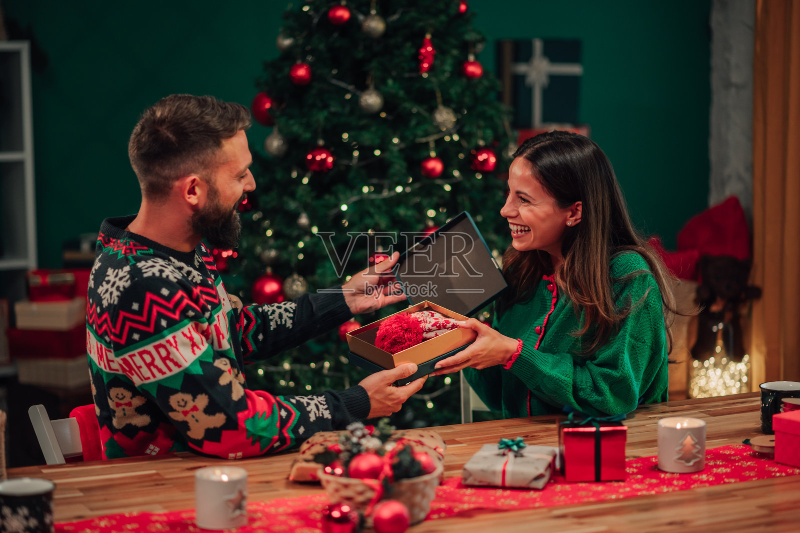 快乐的情侣在家中互赠圣诞礼物照片摄影图片