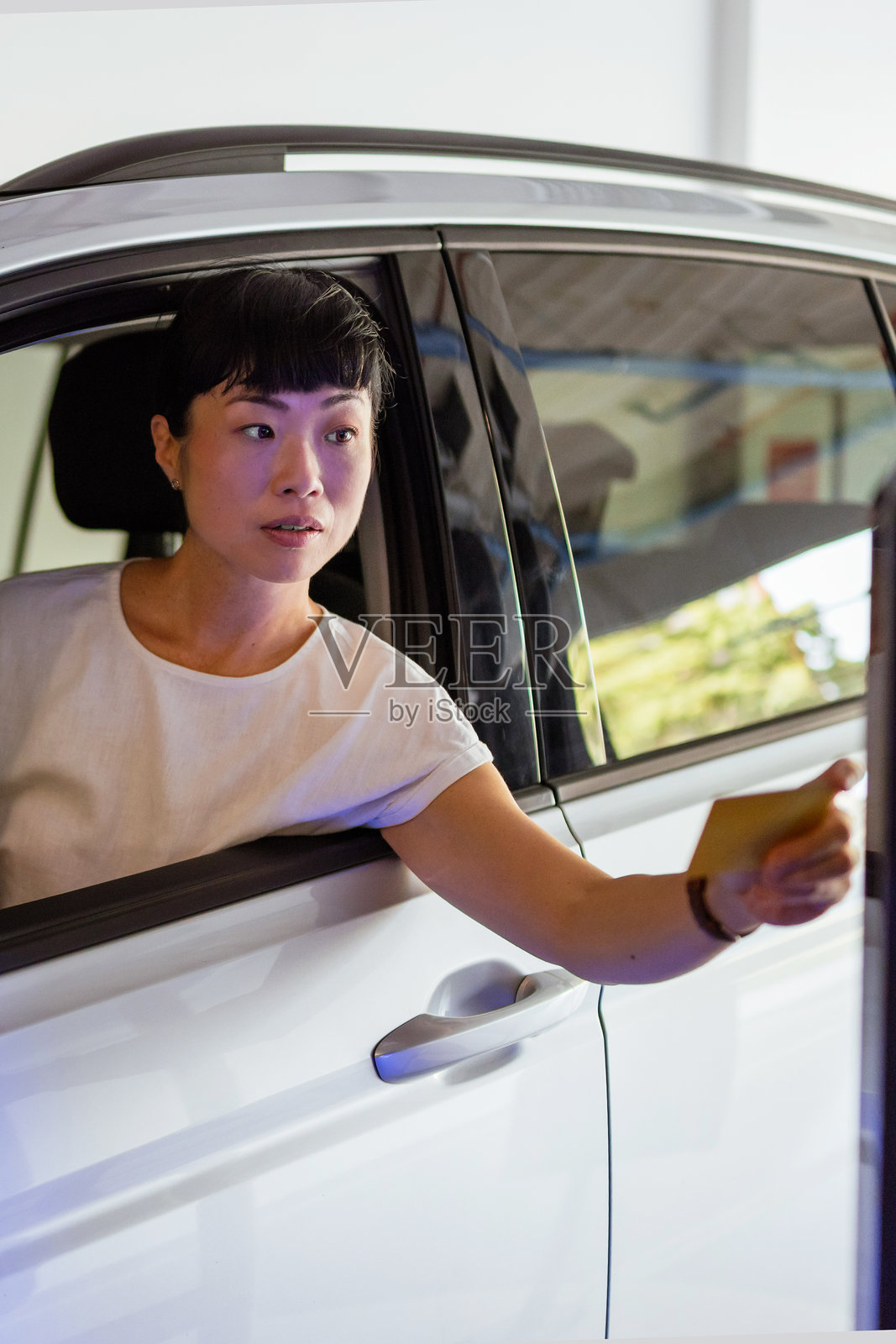 女性司机在地下车库使用刷卡交易完成入场手续照片摄影图片