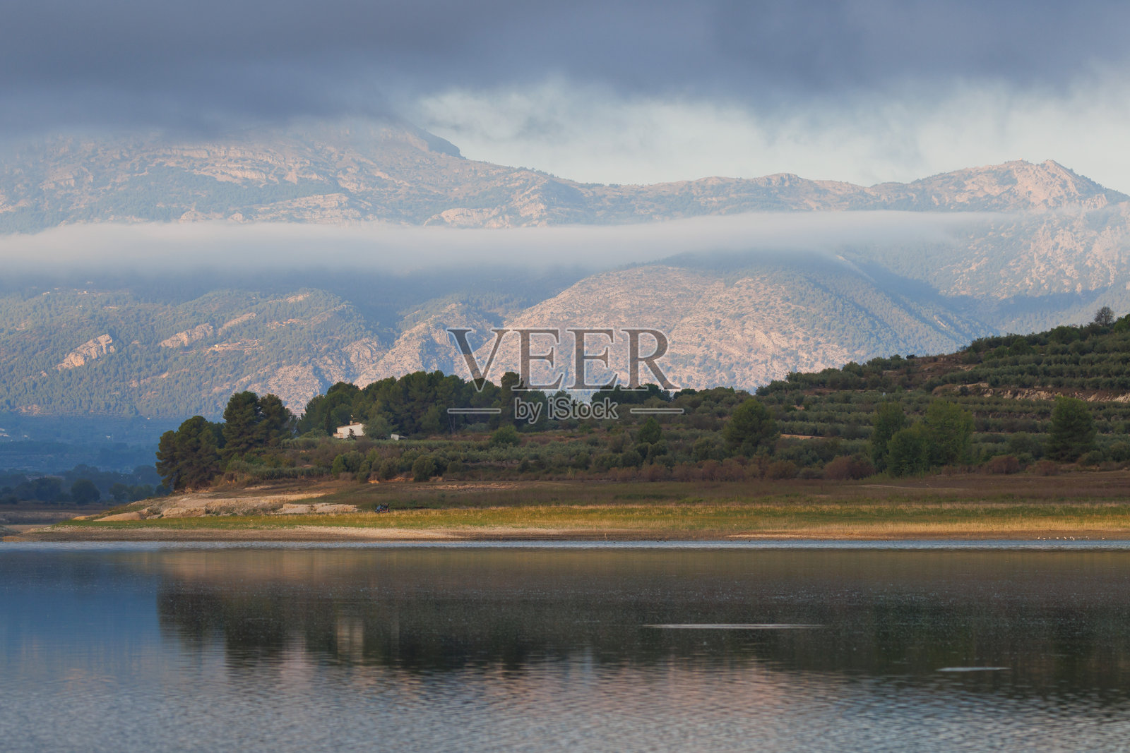 宁静的风景，湖泊贝尼亚雷斯上空有戏剧性的天空，背景是马里奥拉自然公园。照片摄影图片