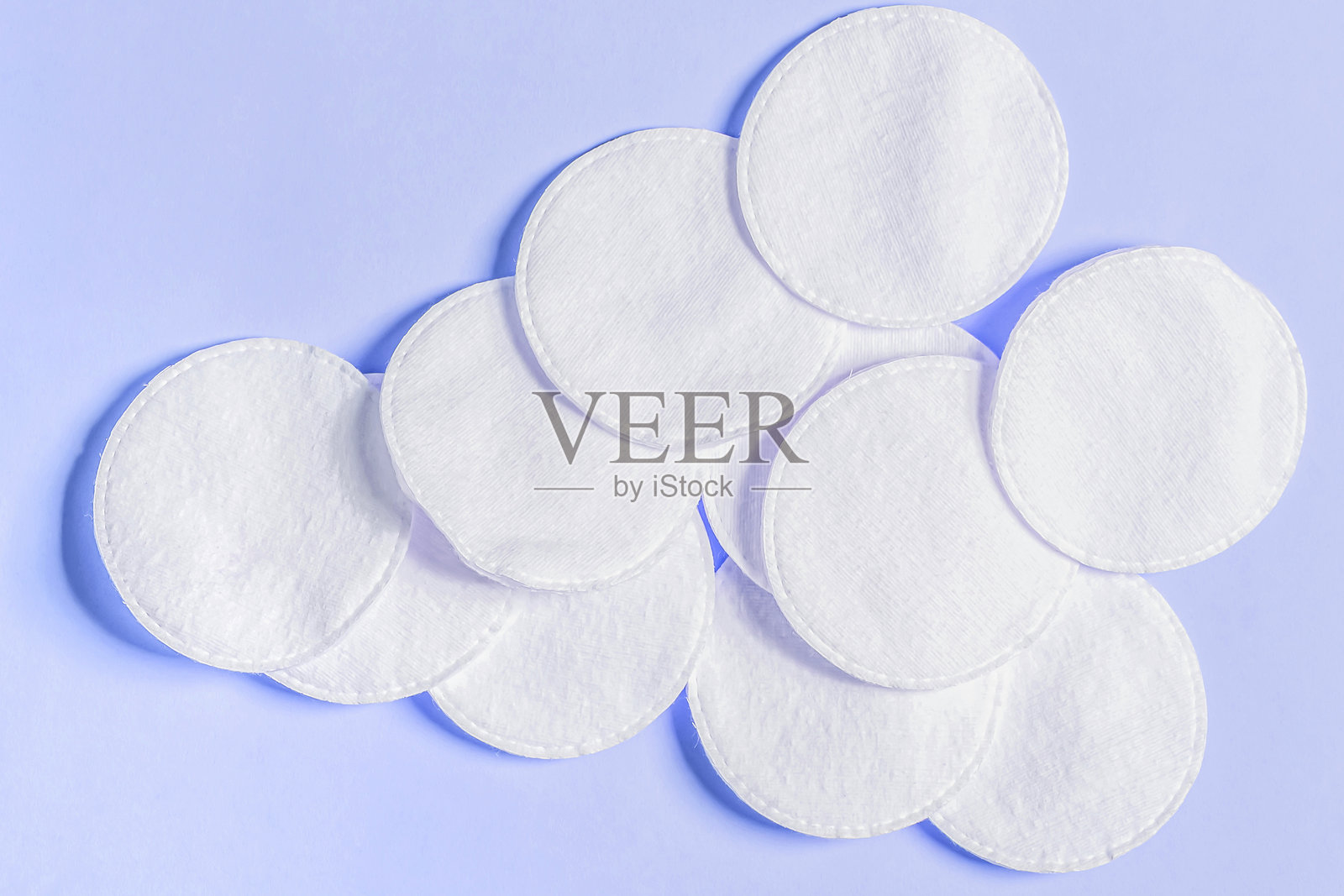 淡紫色背景上的个人卫生棉垫。温和的卸妆产品。平铺展示。照片摄影图片