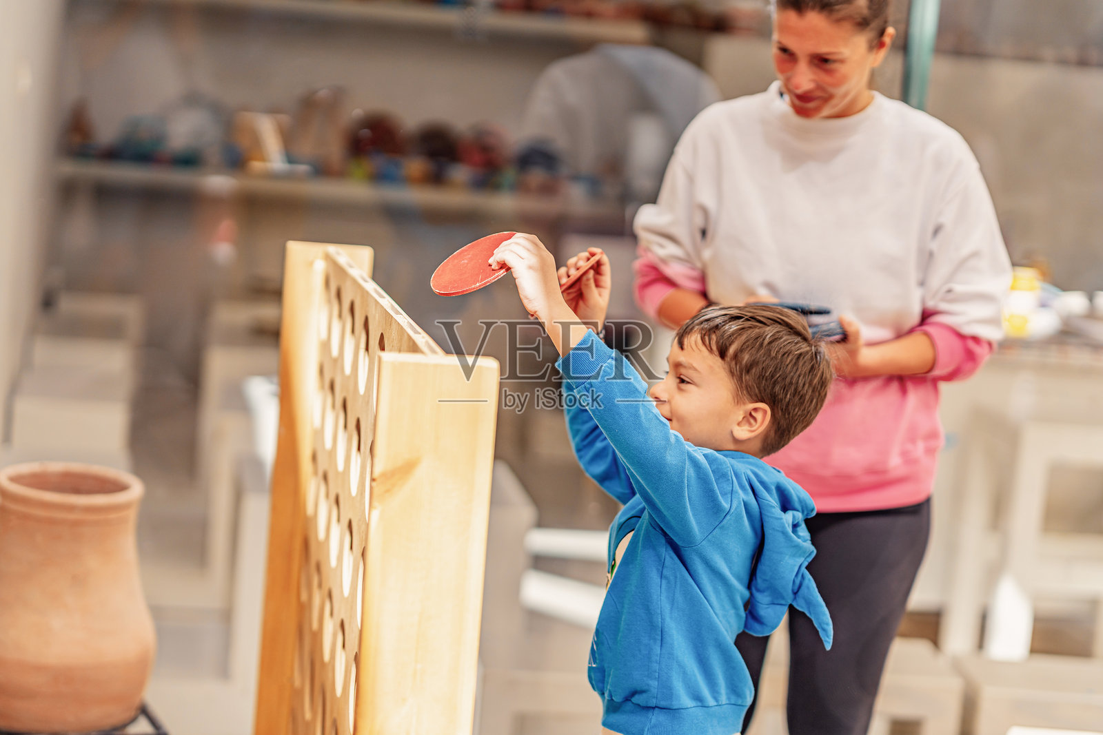 埃及赫尔格达的照片，男孩和妈妈在玩四连珠游戏。照片摄影图片