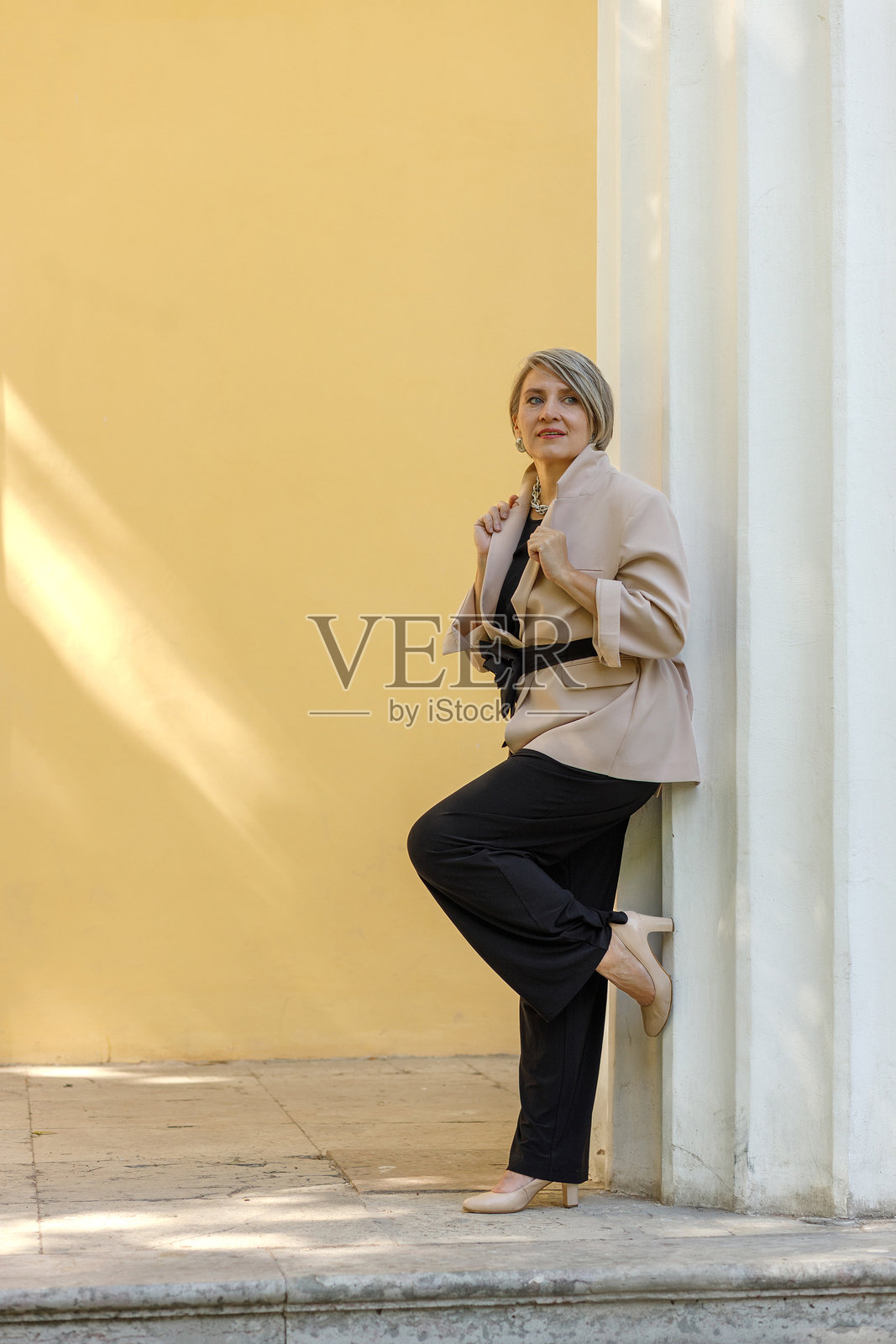 穿着优雅服装的快乐商务女性在公园里摆姿势。照片摄影图片