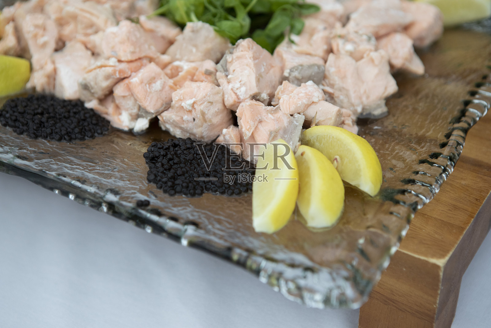 方形玻璃盘上的三文鱼片和柠檬角照片摄影图片