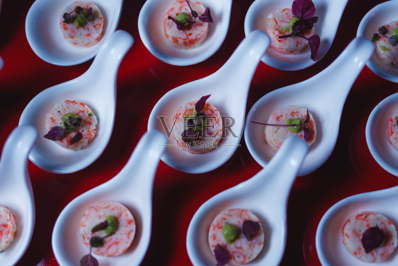 精致海鲜开胃小菜盛放在白色陶瓷勺子上照片摄影图片