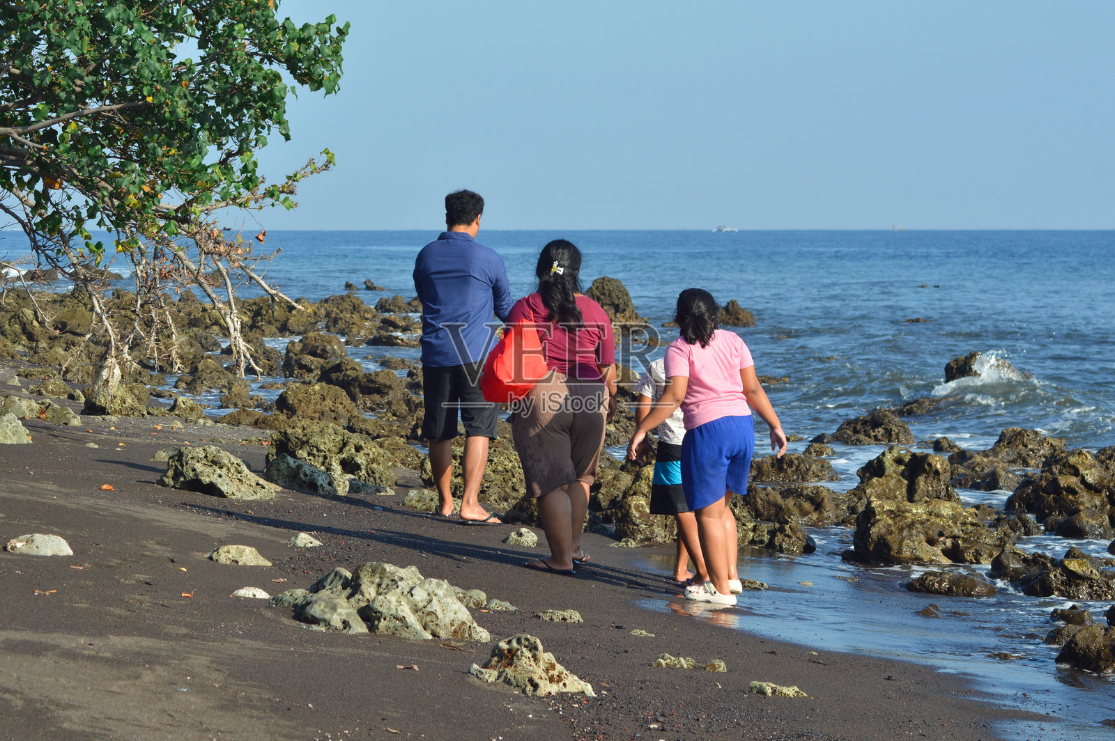 一家人在岩石沙滩的海岸环境中一起探险照片摄影图片