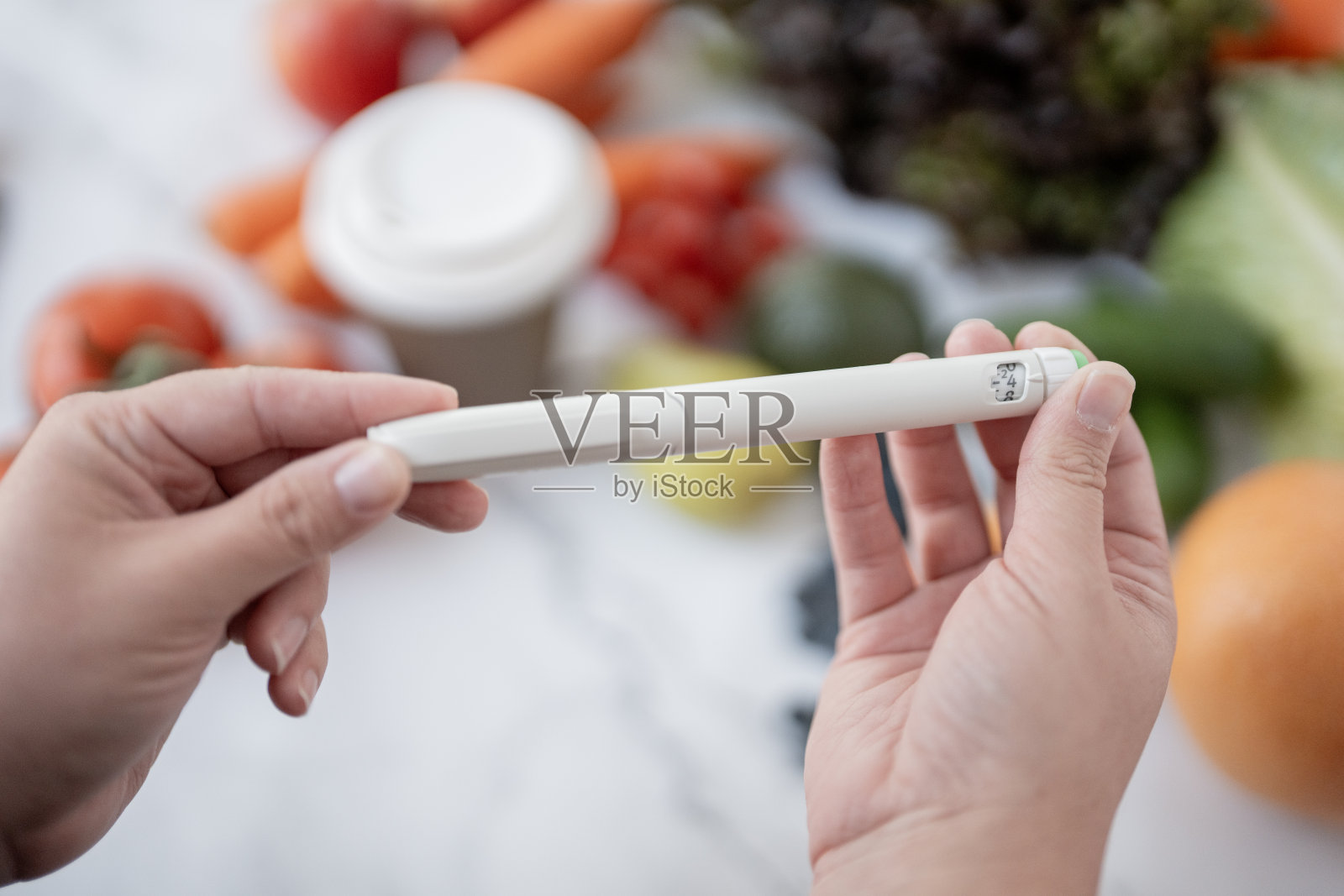 手握笔装置，周围是新鲜蔬菜和咖啡照片摄影图片