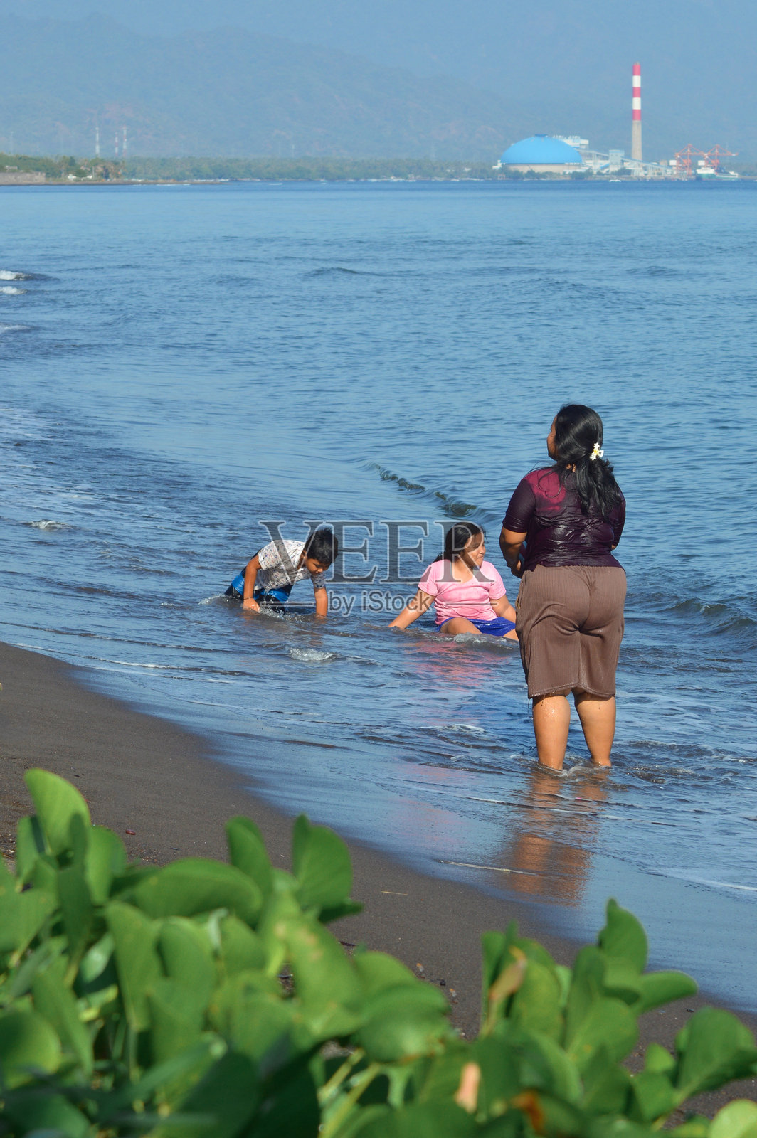 母亲和孩子们在海边享受愉快的早晨照片摄影图片