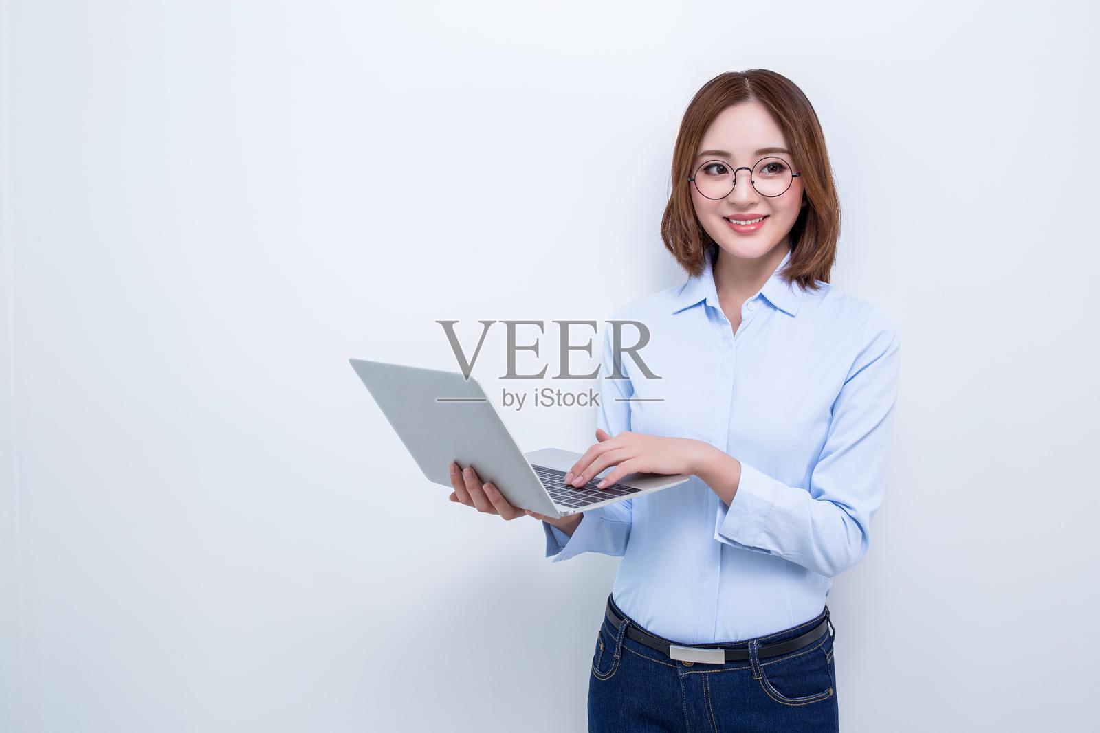 微笑的女性在使用笔记本电脑工作照片摄影图片