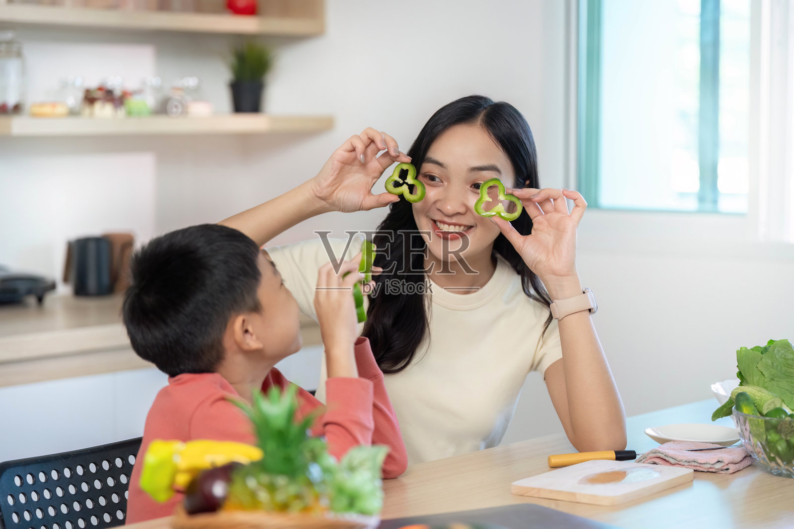 有趣的烹饪：母亲和儿子一起玩蔬菜造型照片摄影图片
