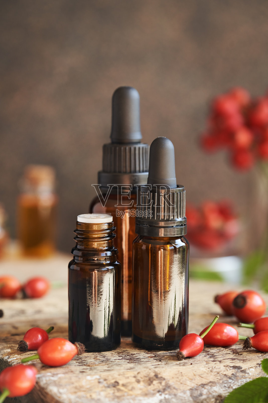 三瓶玫瑰果种子油与新鲜玫瑰果照片摄影图片