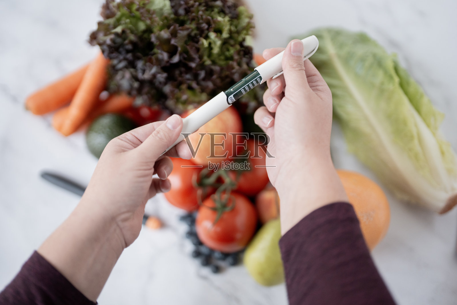 手握设备在大理石表面上的新鲜蔬菜上照片摄影图片