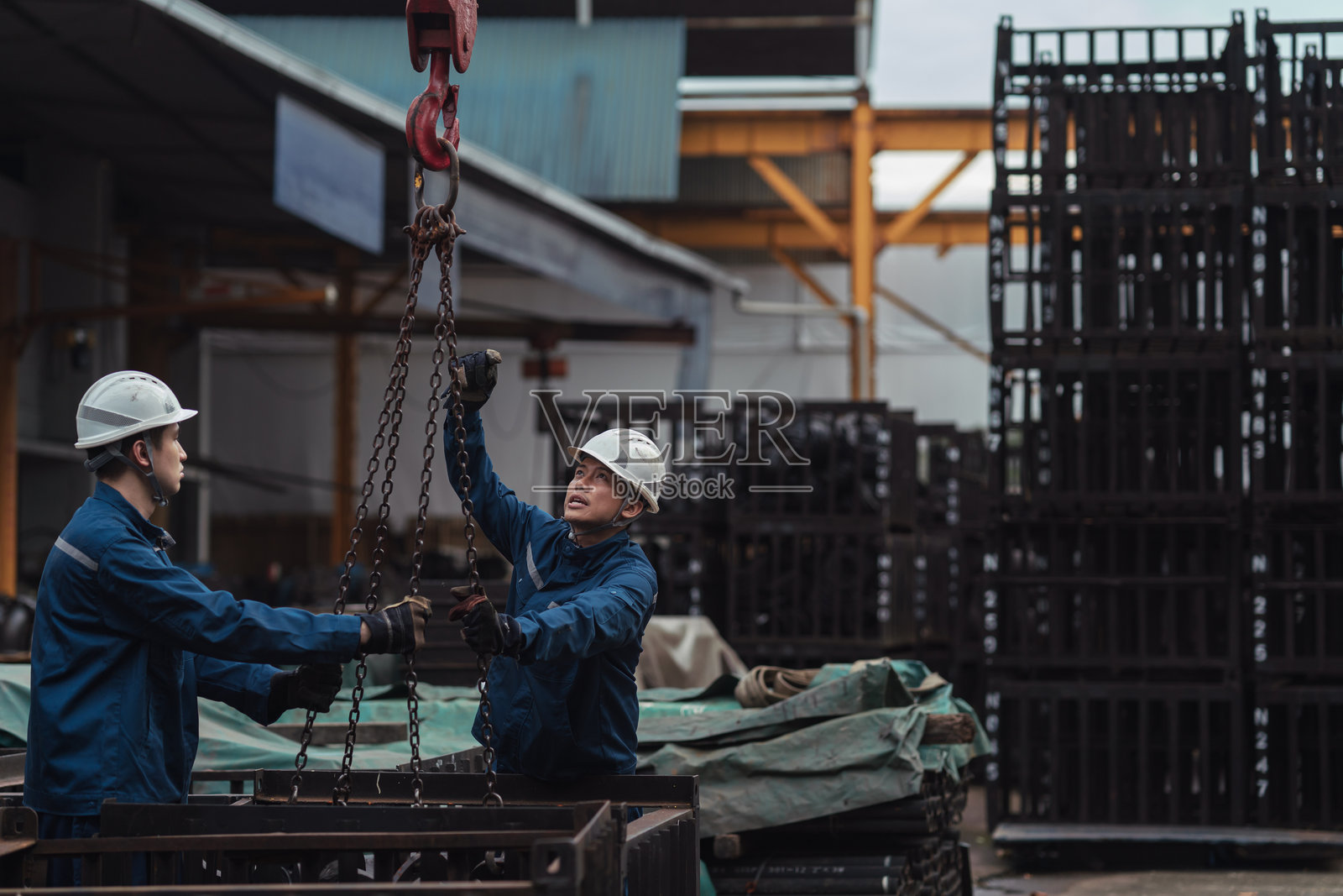 亚洲蓝领工人正在为重物提升搭建链条和滑轮系统照片摄影图片
