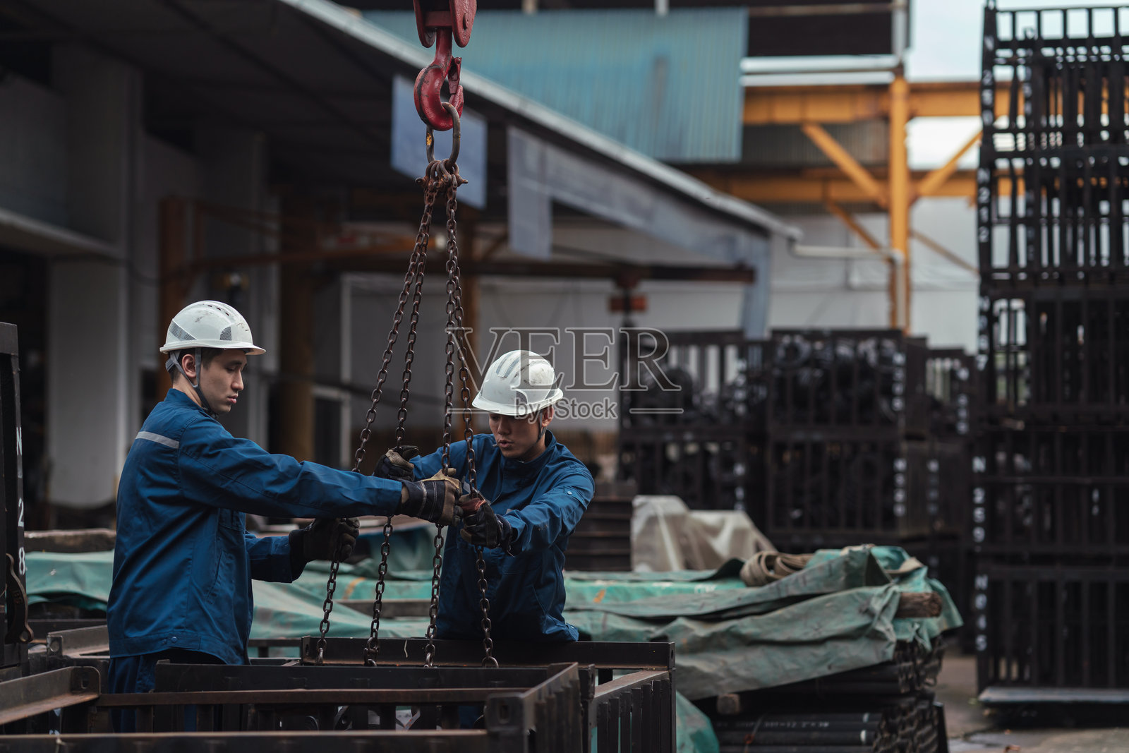 亚洲蓝领工人正在为重物提升搭建链条和滑轮系统照片摄影图片