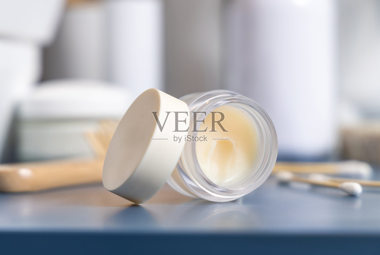 打开唇膏罐附近的个人护理产品的蓝色近距离，化妆品模型照片摄影图片