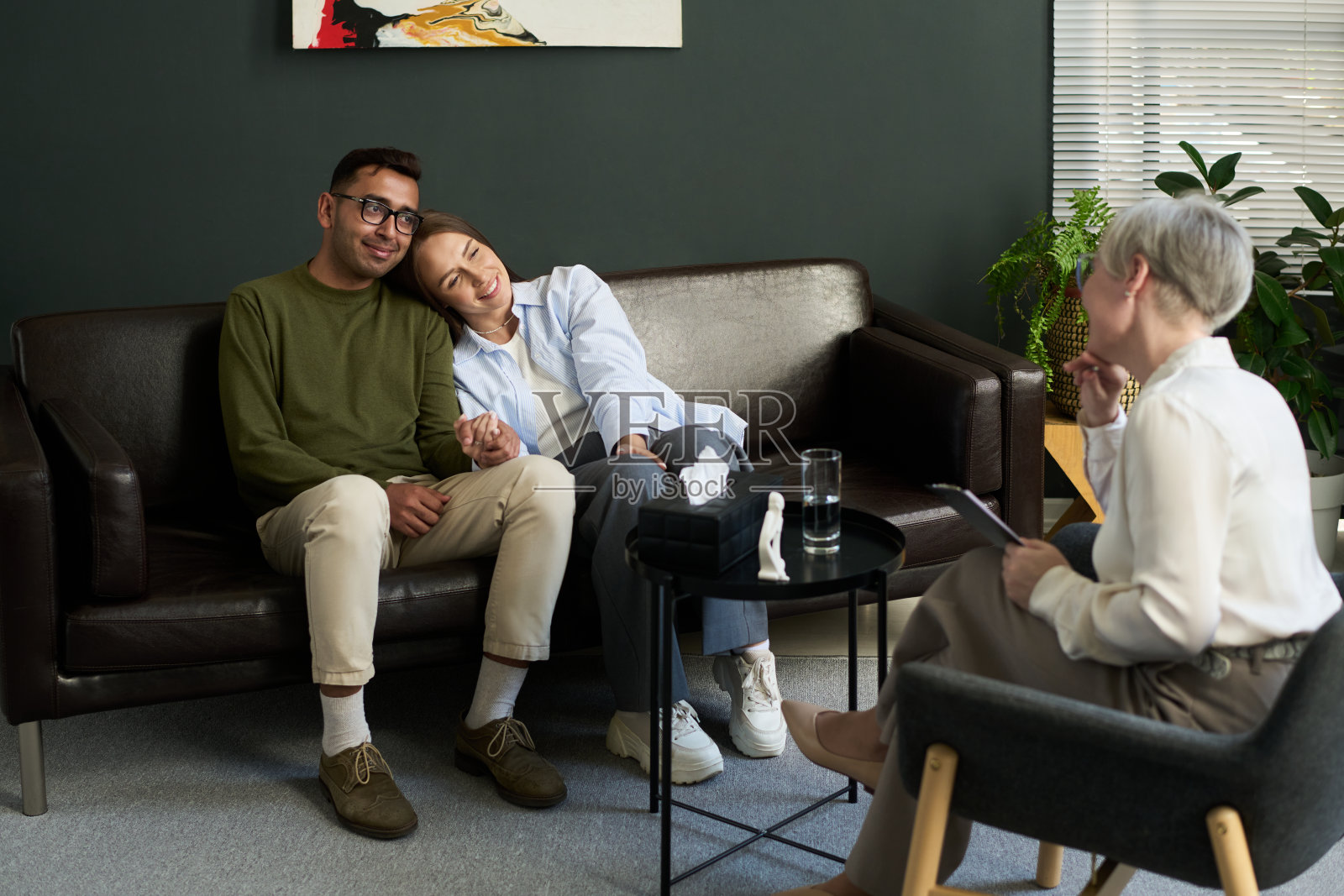 年轻的多民族情侣在心理咨询师的辅导下牵手照片摄影图片