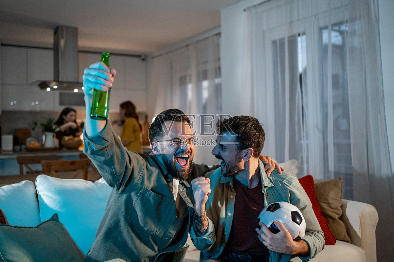 男性朋友在家看电视为足球加油照片摄影图片