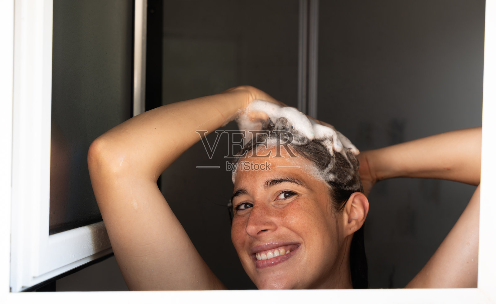 女人在浴室用肥皂洗头照片摄影图片