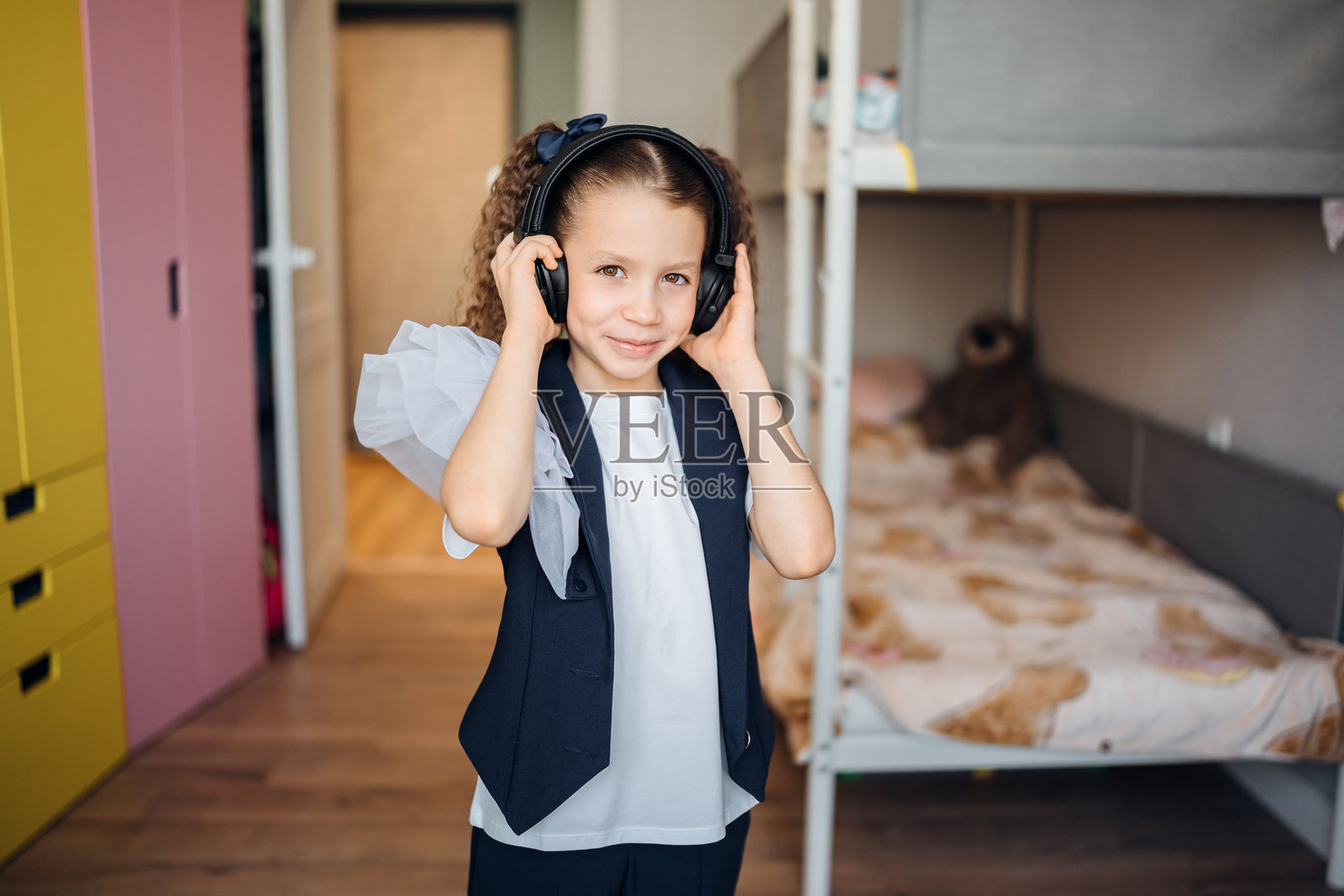 孩子在舒适的卧室里戴着耳机享受音乐照片摄影图片