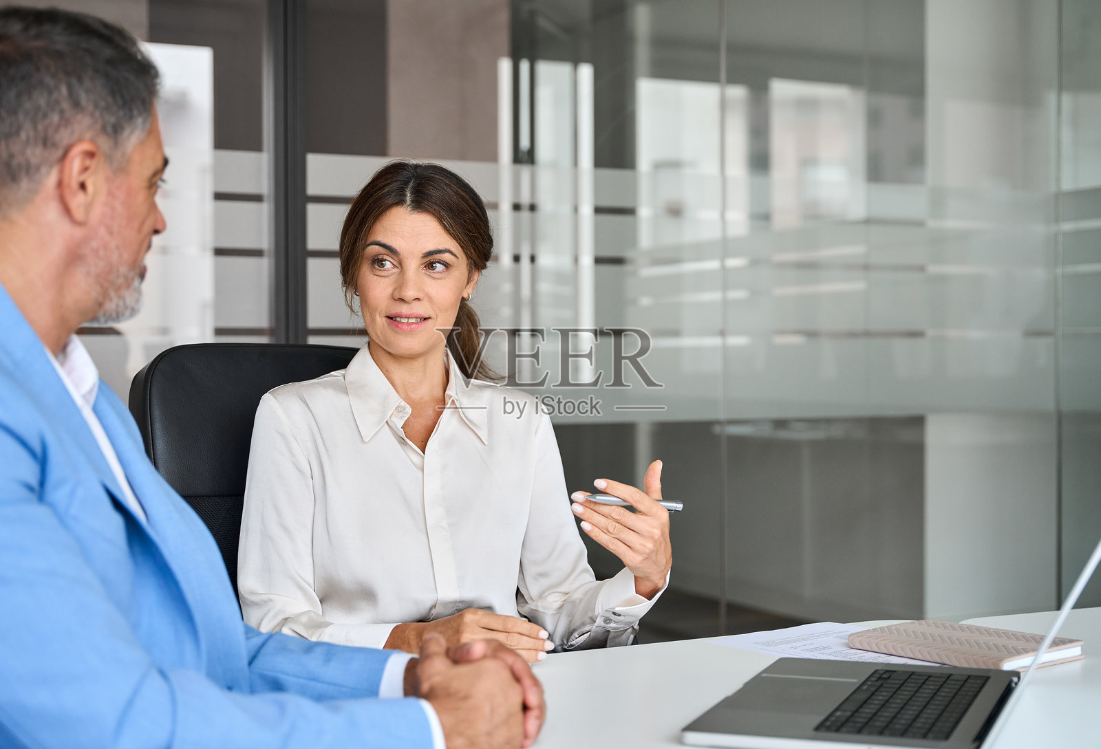 女性专业银行经理在办公室会议中与投资客户进行咨询。照片摄影图片