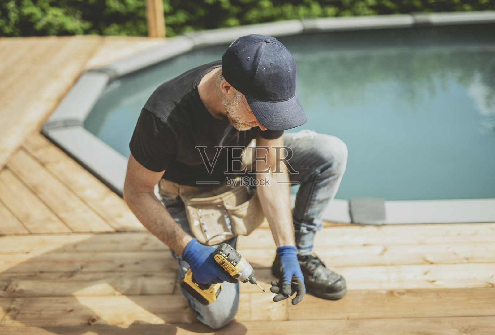 工人正在游泳池旁边的露台上进行维修工作照片摄影图片