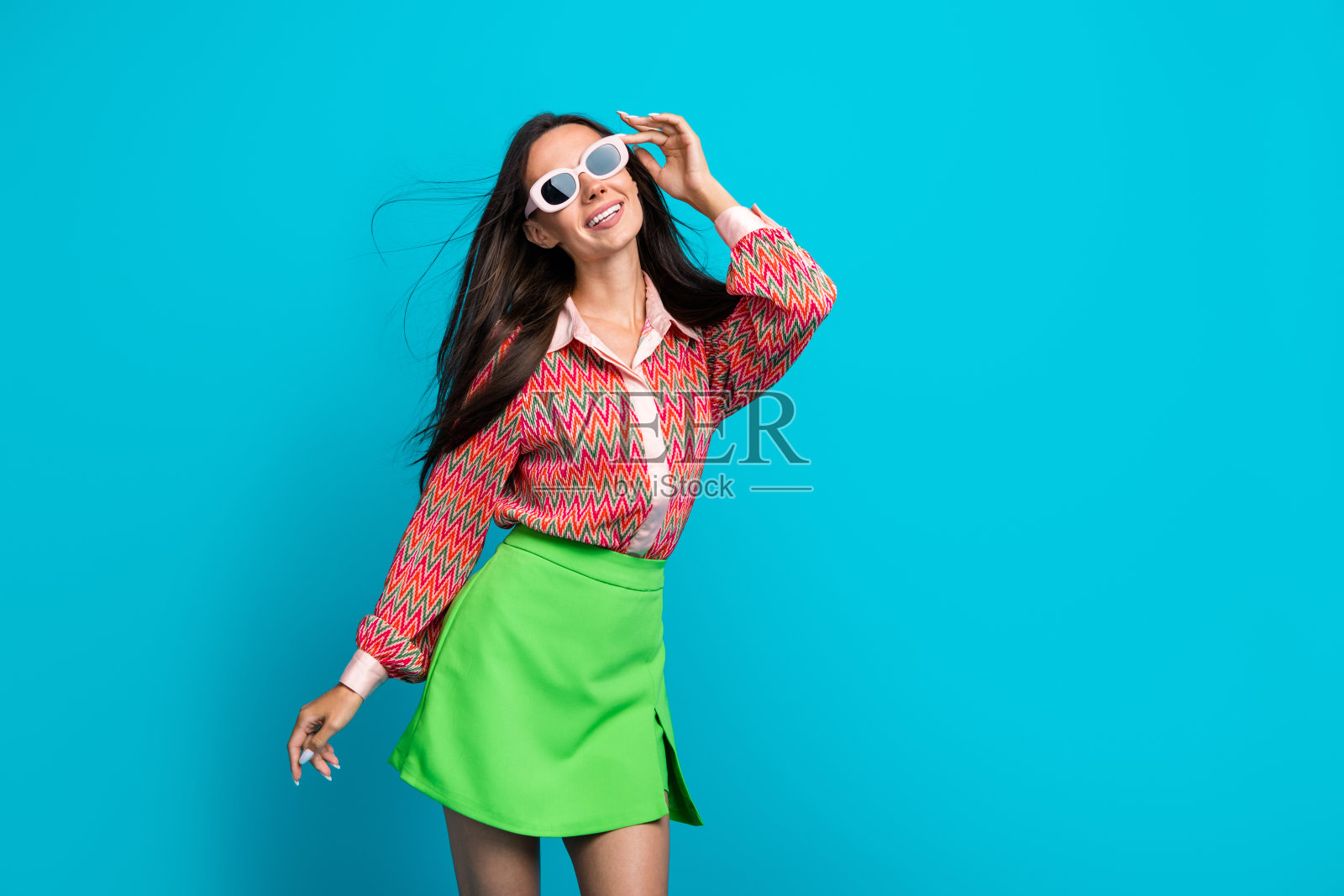 迷人的舞蹈女士，身材纤细，佩戴太阳镜，穿着休闲夏季服装，背景为青绿色。照片摄影图片