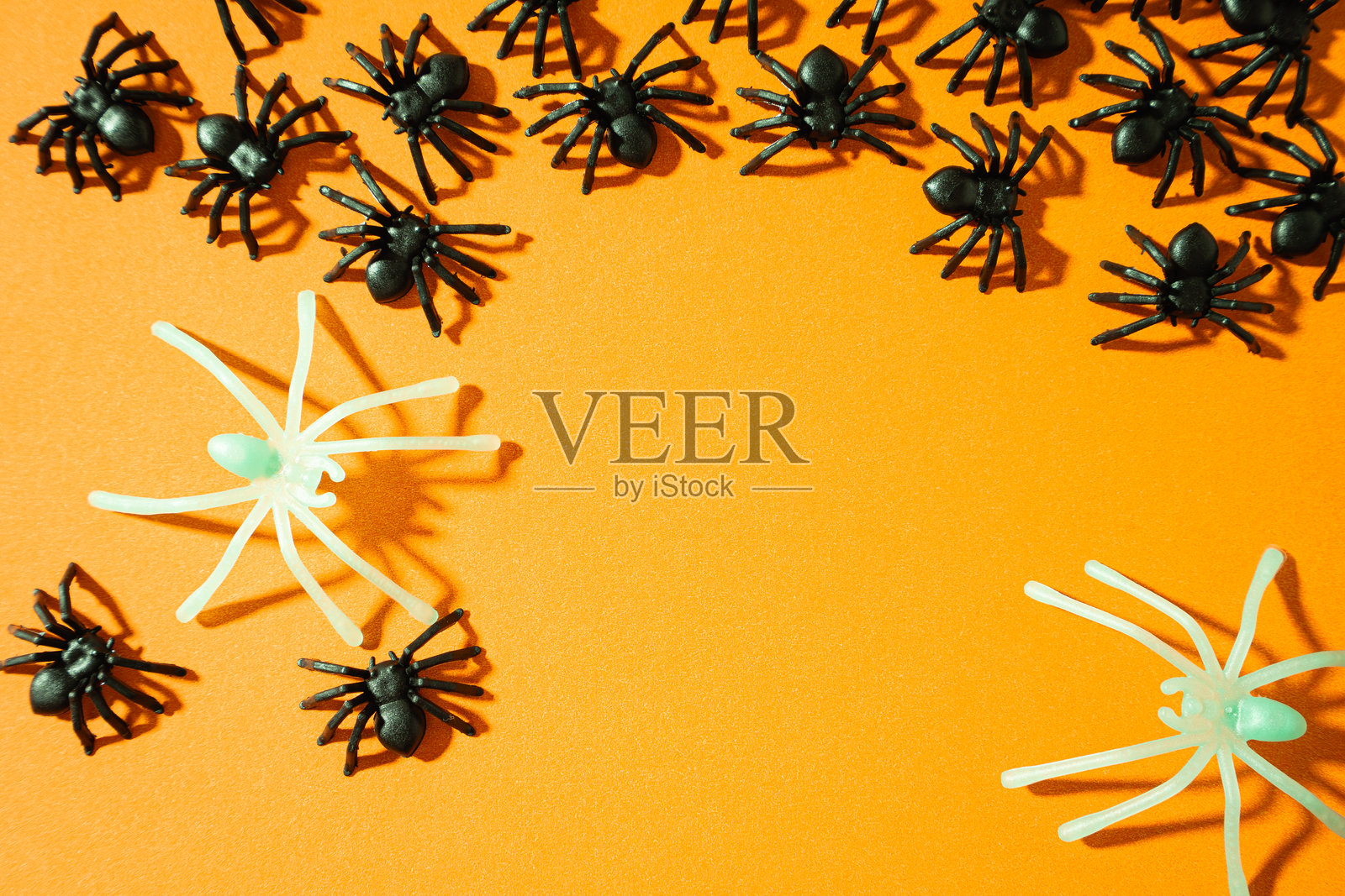 橙色背景上的假蜘蛛。万圣节背景照片摄影图片