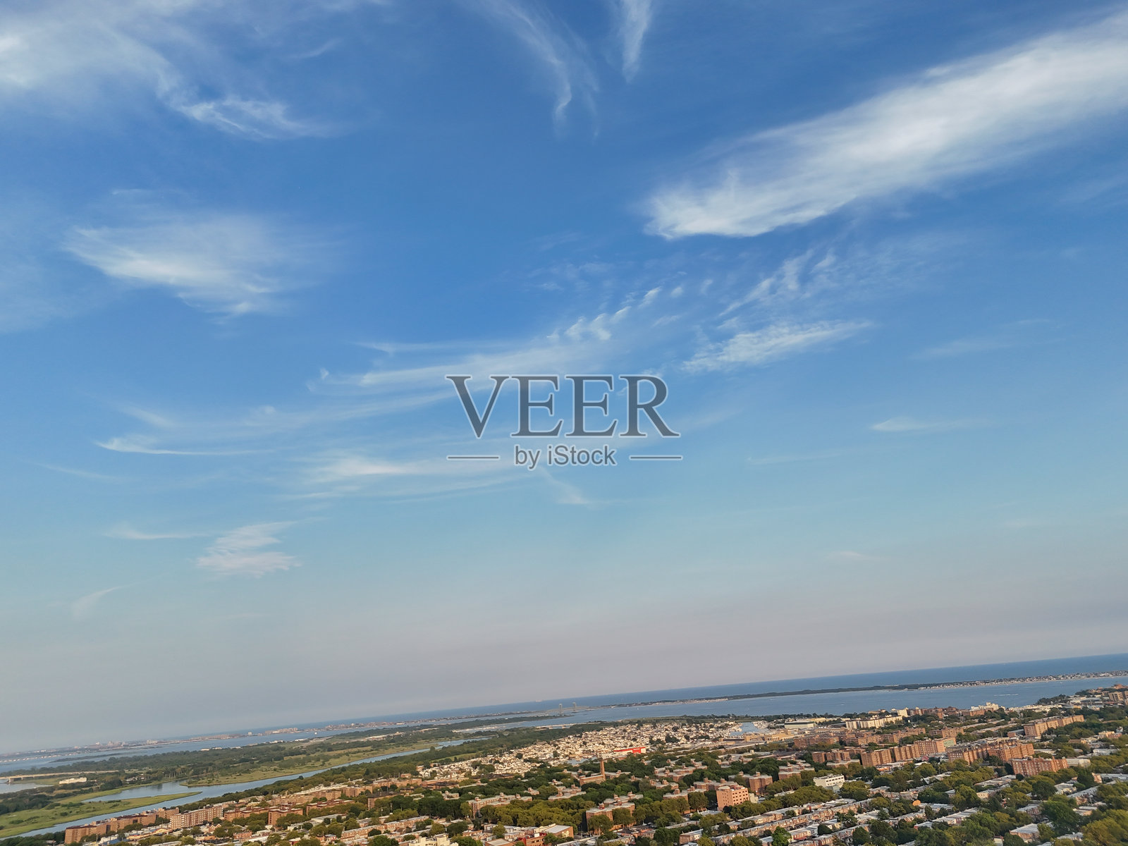 湛蓝的天空中飘着稀疏的白云，暗示着一个晴朗的天气日。照片摄影图片