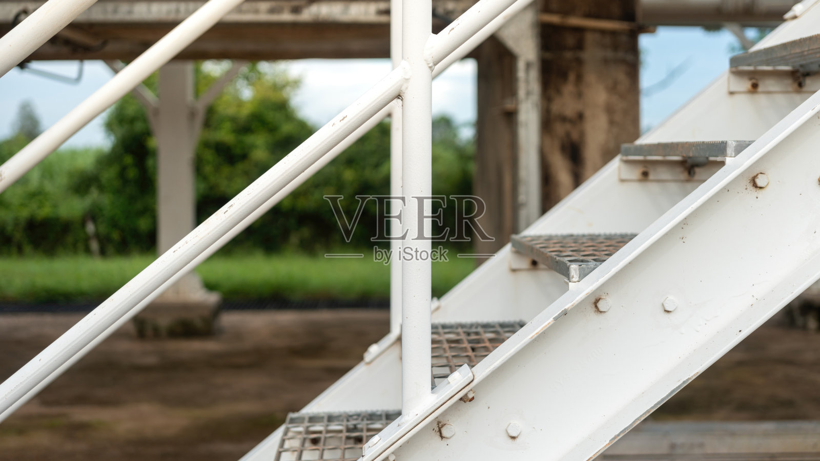 一座横跨生产管道的天桥步道。照片摄影图片