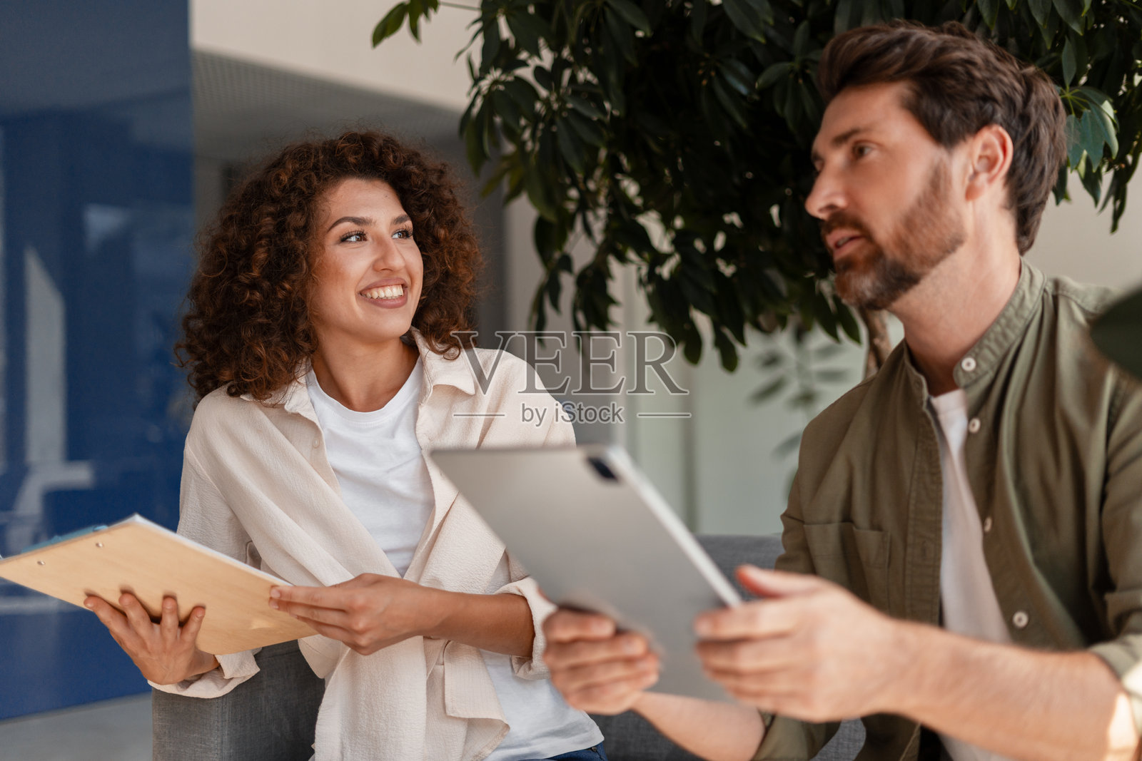 商务伙伴在办公室讨论使用数字平板和夹板照片摄影图片