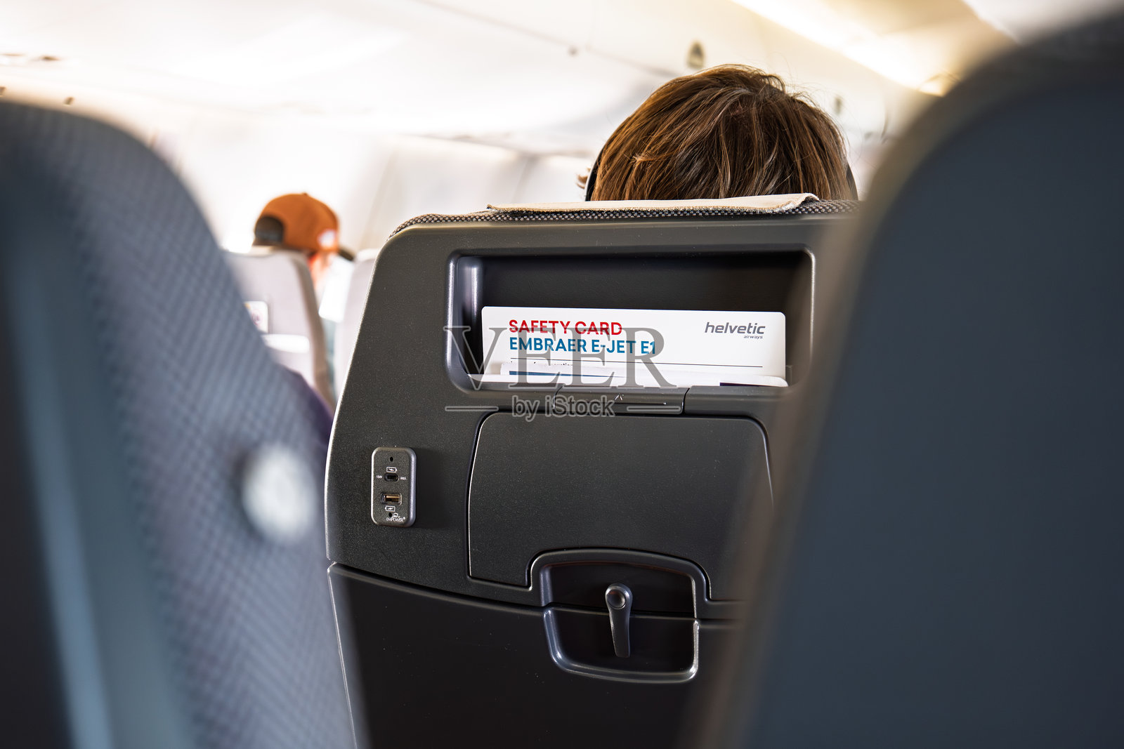 商业飞机客舱后座口袋里的飞机安全信息卡。照片摄影图片