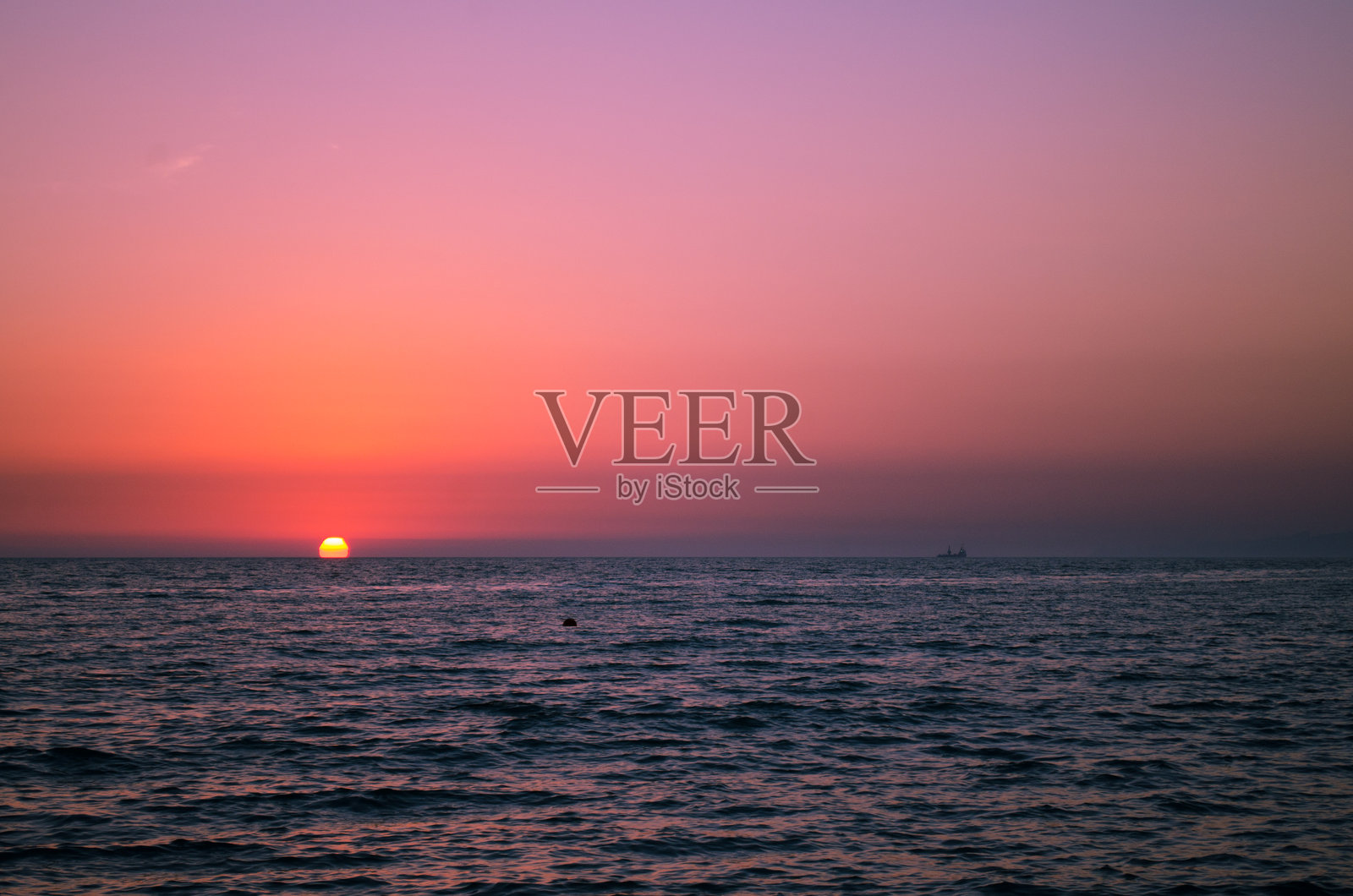 宁静的海洋日落，橙色和紫色的天空照片摄影图片