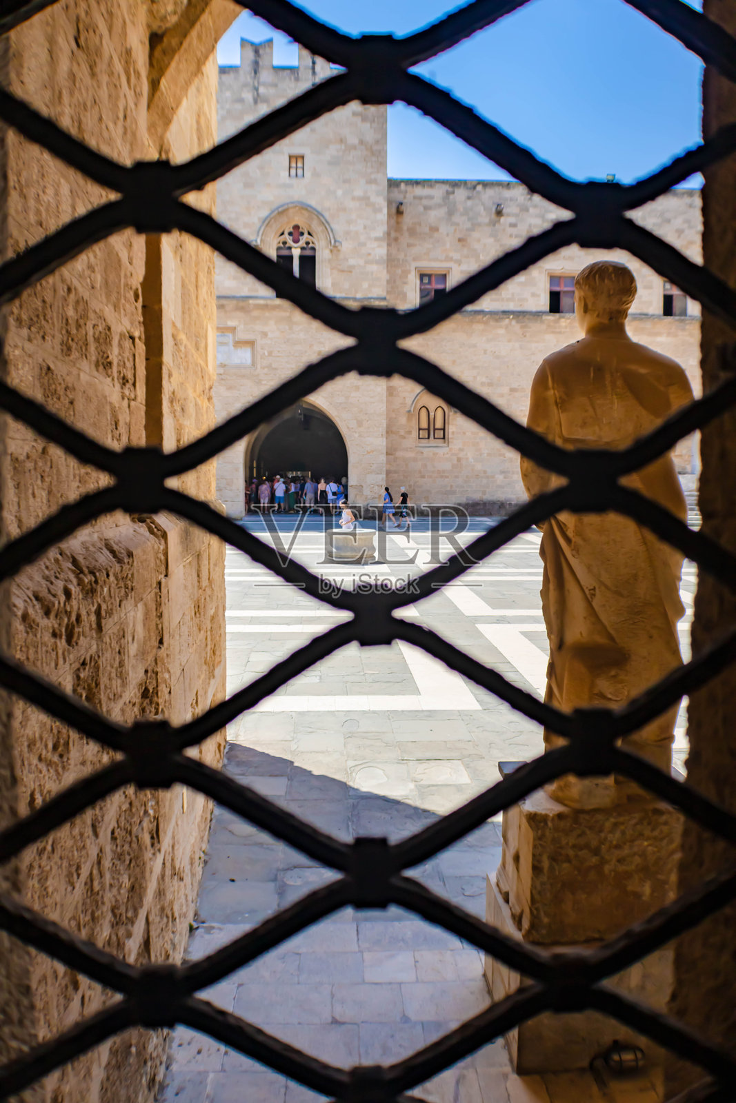 透过窗户铁栏杆看到的罗德岛大骑士宫的内 courtyard,希腊照片摄影图片