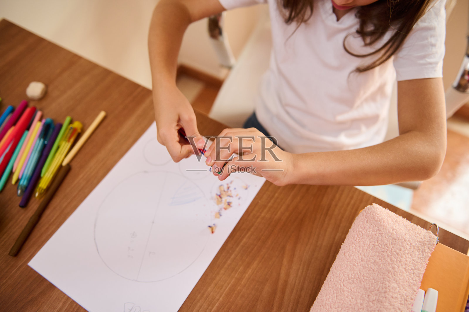 年轻学生在书桌上用学习用品削铅笔照片摄影图片