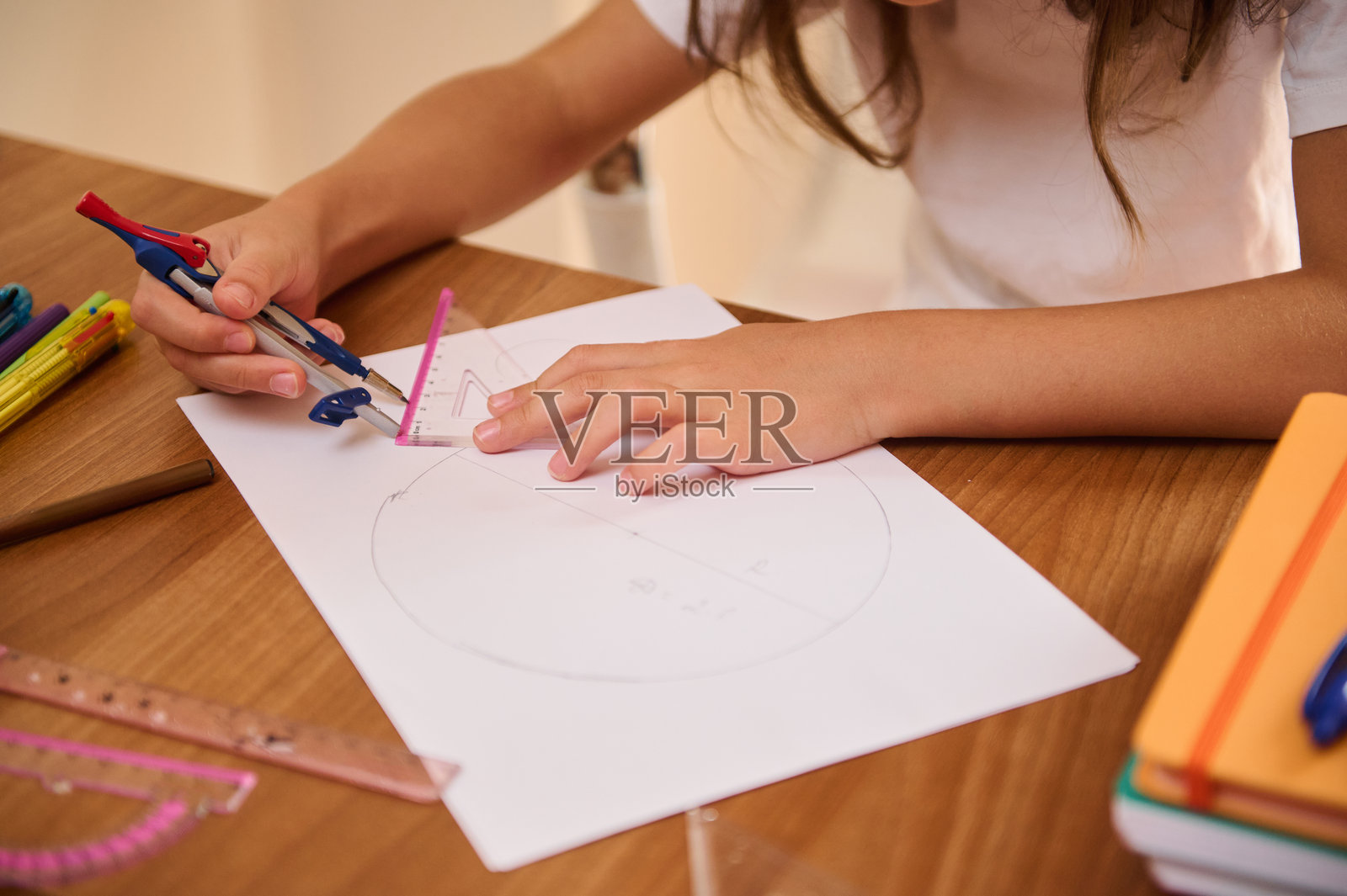 年轻学生在木桌上使用几何工具绘制圆形照片摄影图片