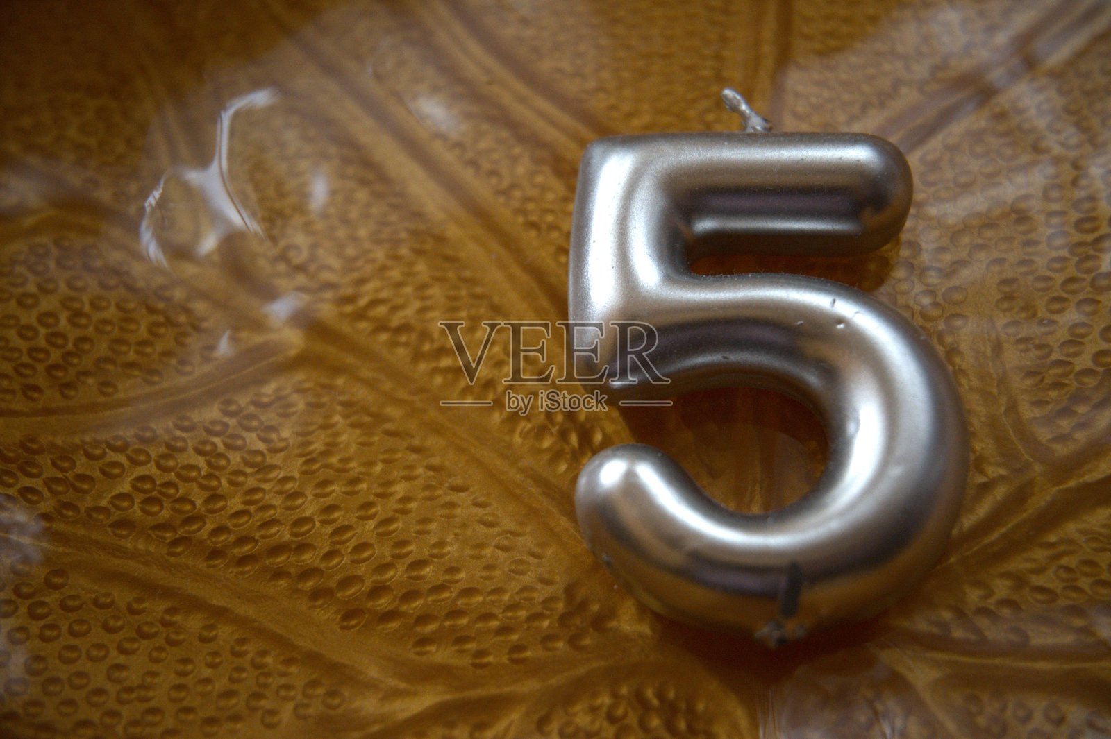 叶子图案盘子上的5号生日蜡烛特写，留有空白空间照片摄影图片