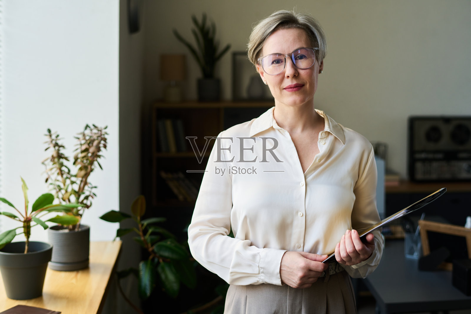 微笑着手持夹板的女性心理学家肖像照片摄影图片