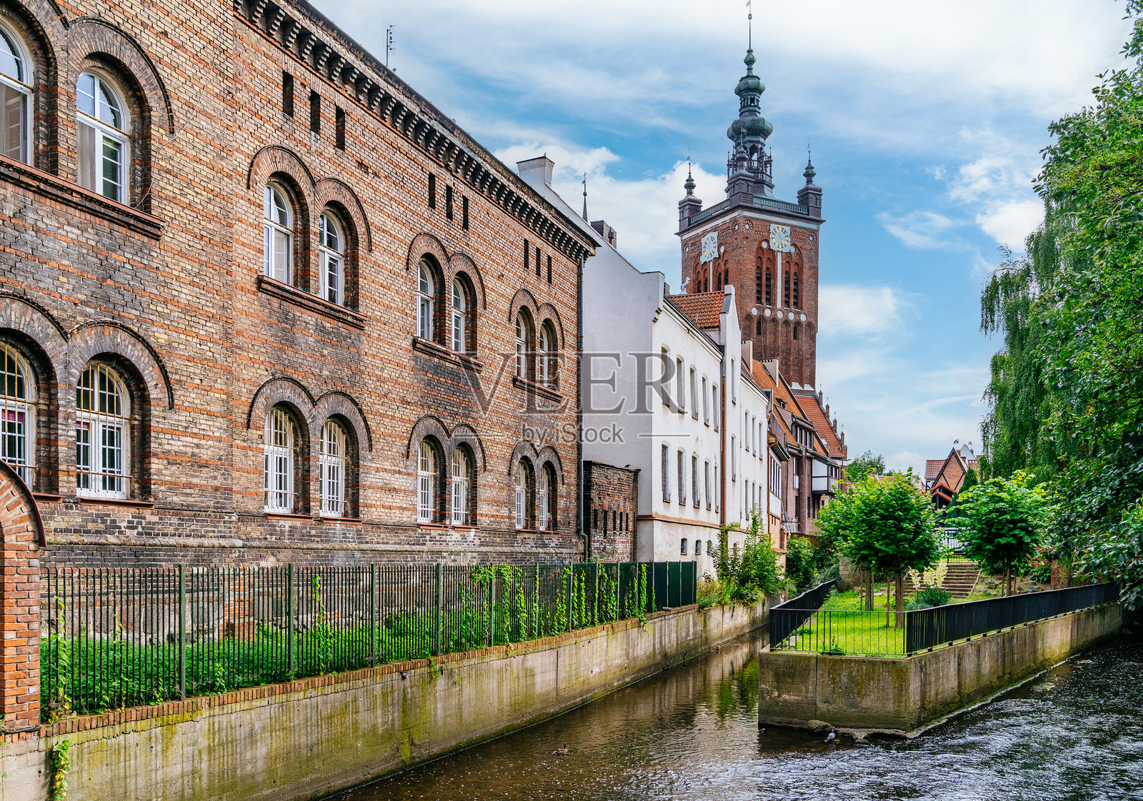 格但斯克老城沿水道矗立的砖砌历史建筑，带有拱形窗户和塔楼照片摄影图片