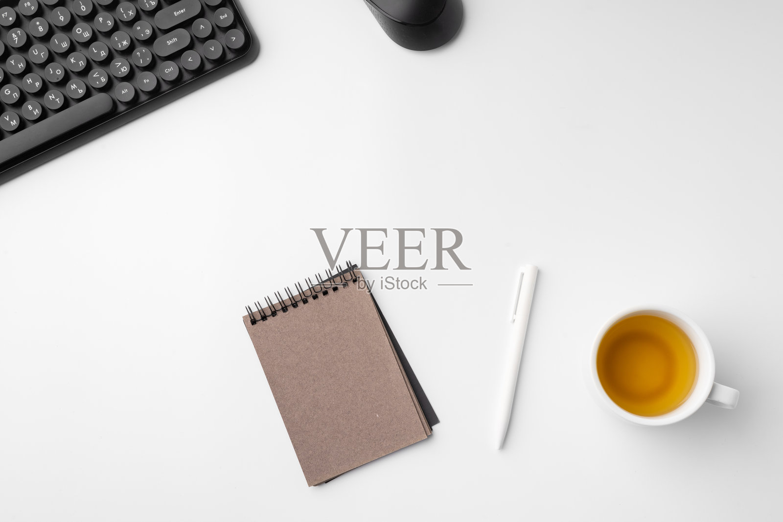 简约的白色工作空间，配有键盘和笔记本。照片摄影图片