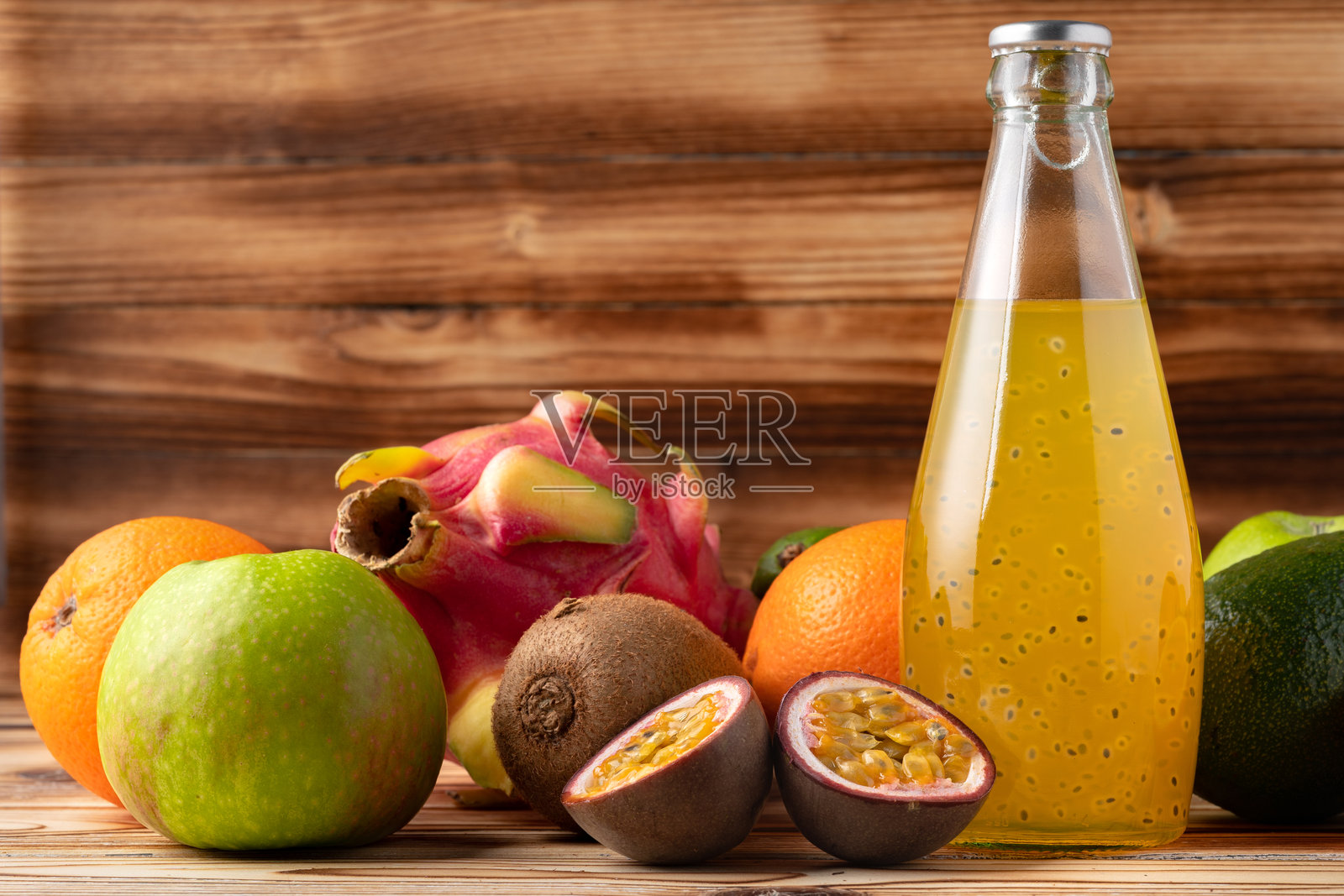 玻璃瓶中的果汁饮料和木质背景上的新鲜水果照片摄影图片