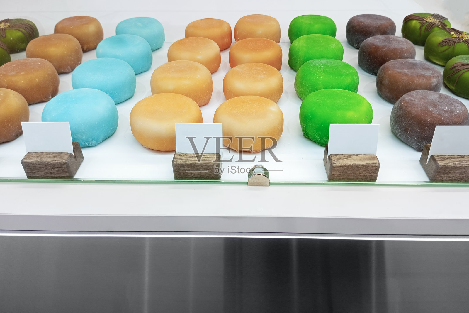 咖啡馆窗户里的五彩糯米团甜点。照片摄影图片