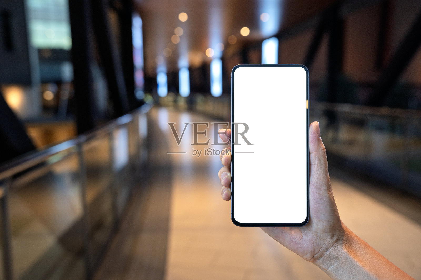 在购物中心手持空白屏幕的智能手机照片摄影图片
